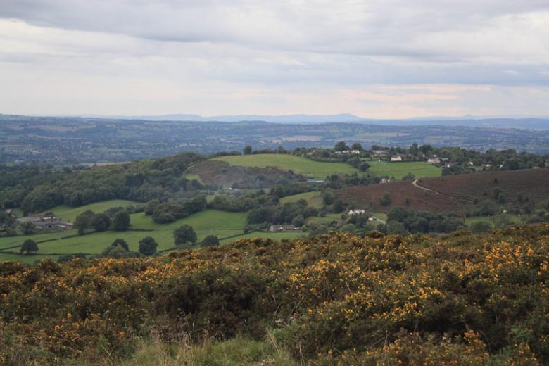 Photo taken from a mountain looking out over the countryside towards more mountains